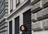 a woman in black long sleeves standing on the sidewalk
