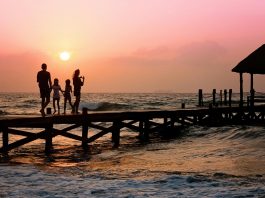 people standing on dock during sunrise