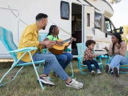 a family sitting beside the campervan